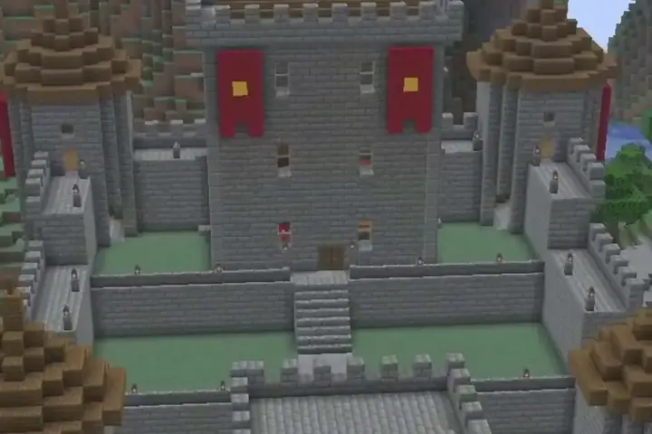 A stone castle with red banners and brown round towers, built into a mountainside